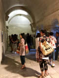 Visitors crowd the hallways for the opening of the exhibition, where framed works line the hallway.