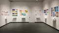 Install image showing three gallery walls with six installations of books on shelves with individual pages pinned to the wall.
