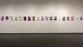 Install image showing a large gallery wall with many prints lining the walls in a row.