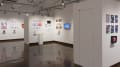 The third gallery space is visible from another angle. More student work can be seen on surrounding walls.
