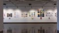 Prints, originals, and books are all displayed on a wall of gallery one.