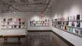 Colorful books are displayed in three rows, lining the walls of gallery four. 