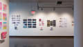 Prints, originals, and books are all displayed on a wall of gallery one.