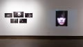 Installation image showing 5 black and white photos on the left and a large portrait on the right.