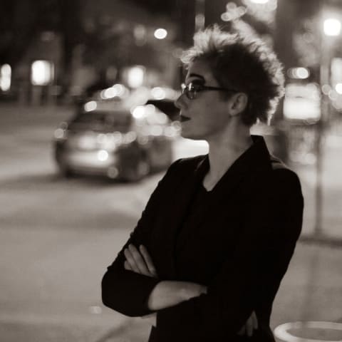 Black and white portrait of Anna Eveslage outside at night on a city street