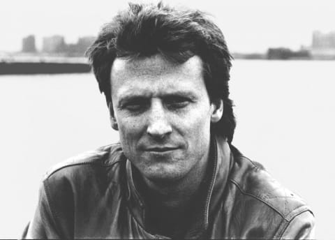 A man with black hair is wearing a black jacket.