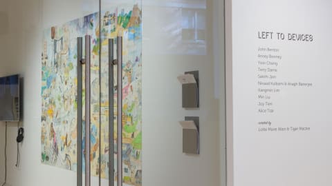 View from right outside primary gallery space, with exhibition title and artist names applied to wall beside door.