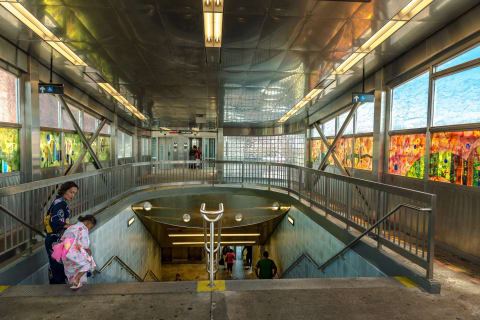 Alt: Photo of Far Rockaway Mott Avenue station, two people wearing kimonos. 