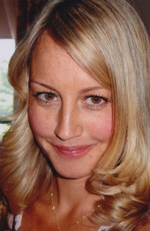 Close up photo of blonde a girl smiling.