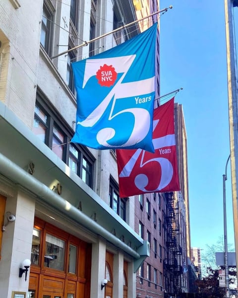 A photo of the front of an SVA building with two flags hanging out front, each flag reads "75 years" with the SVA logo on it.
