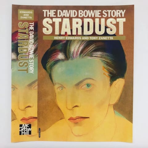 A book cover featuring an illustration of David Bowie in yellows and with a blueish tint on his forehead. Above him is the title "Stardust: The David Bowie Story"