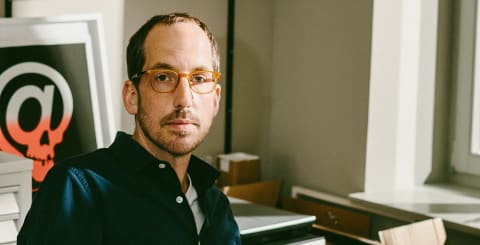 Man wearing glasses sitting in a classroom.