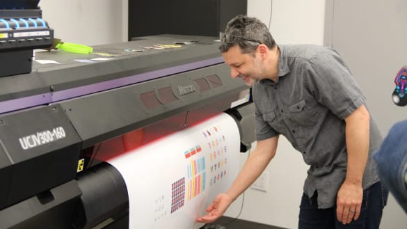 Instructor waiting as a color printer produces a very large sheet.