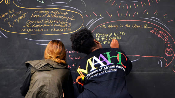 Diverse Students writing on a chalk board