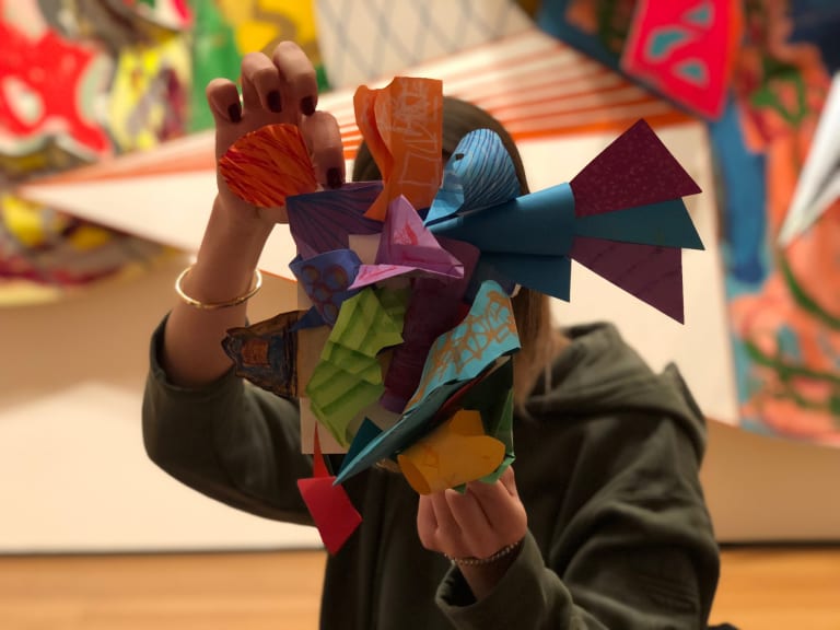 Person holding up a paper sculpture