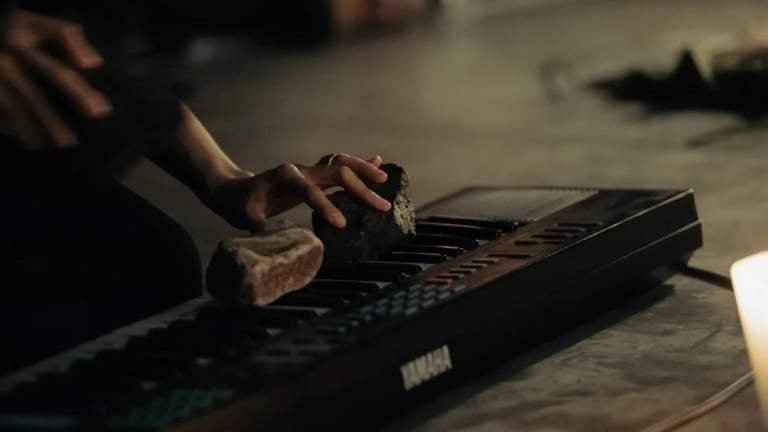 Photographic image of a hand one a keyboard.  The keyboard has two ricks on it.