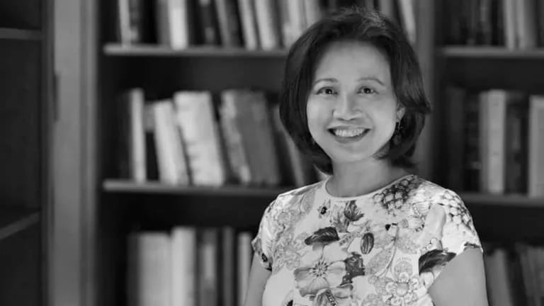 Scholar Anne Anlin Cheng standing in front of bookshelf, black and white photo