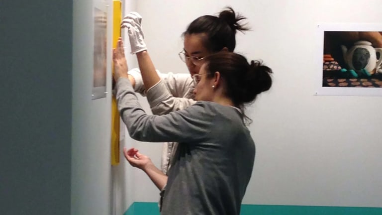 Two students installing an artwork 