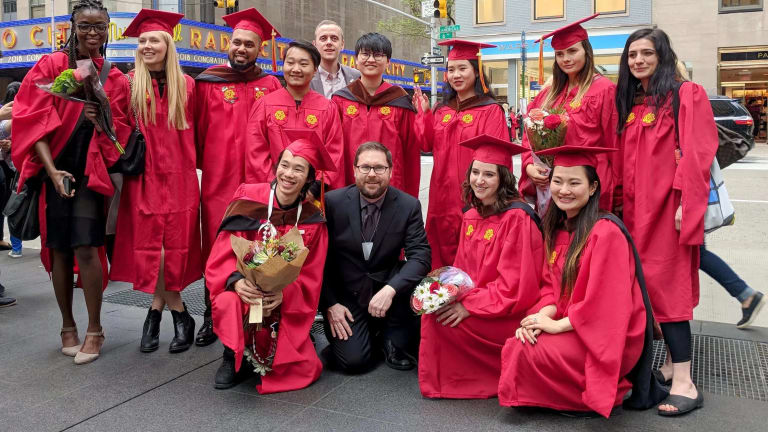 The graduating MPSDP class of 2019 stands on the street with the Radio City Music Hall in the background.