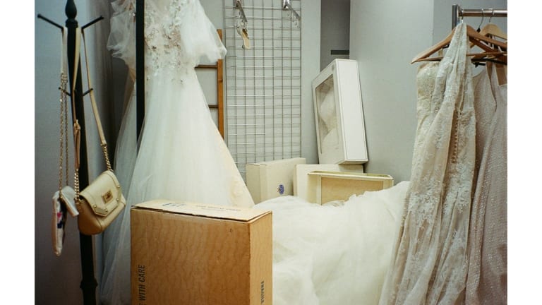 Still from a video by SVA BFA Photography and Video student Geena Janovsky, featuring a dressing room with many wedding gowns hanging and one on the ground.