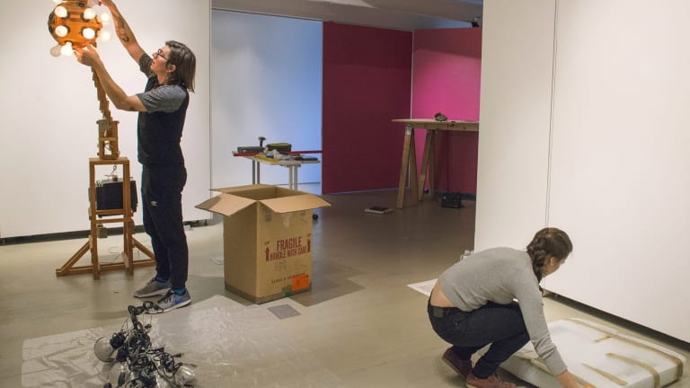 Two SVA MA Curatorial Practice students installing artwork in CP Projects Space