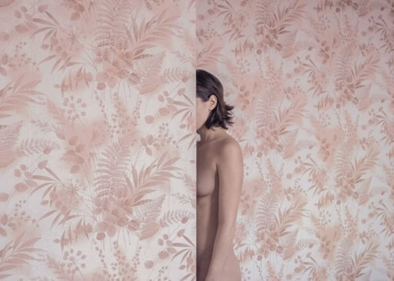 A body hidden by a floral print wall