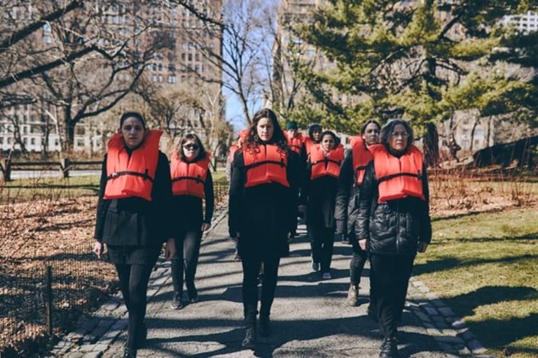 A group of ladies wearing life vests and wearing black.