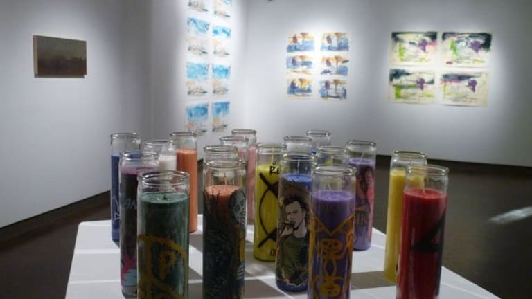 Multi colored artist memorial candles centered in an art gallery