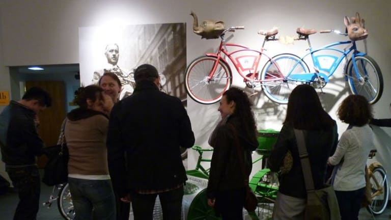 A group of people discuss what could be an art exhibit featuring bicycles.