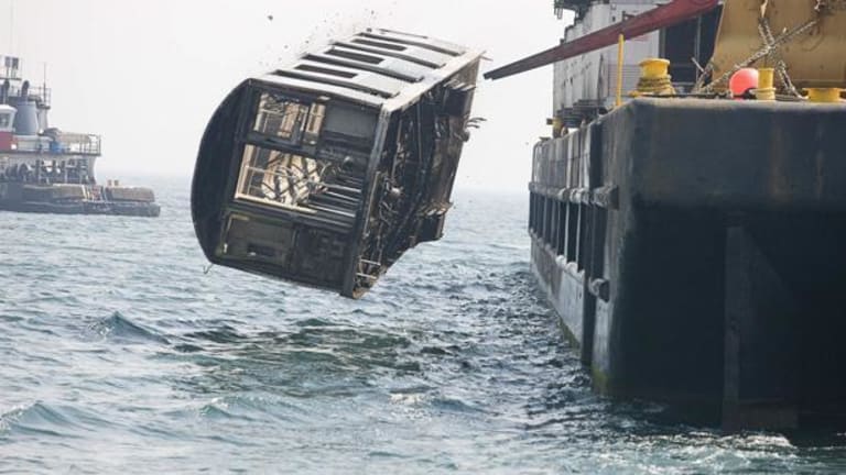 A subway car being dropped into the ocean.