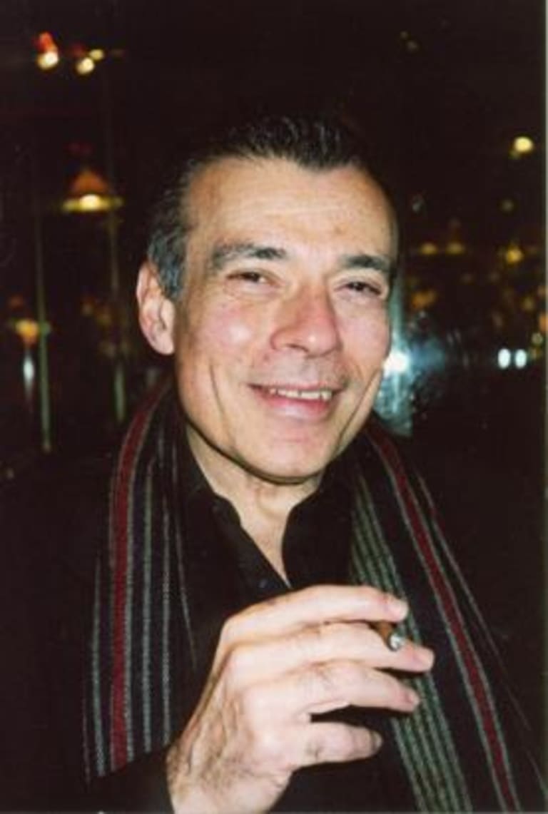 man smiling holding cigarette in striped scarf