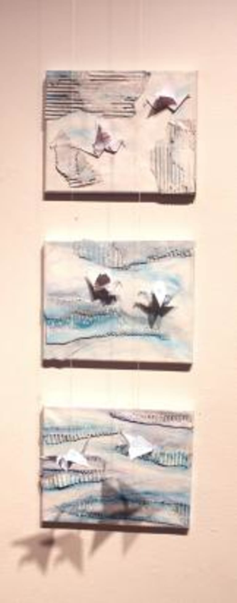 Three canvases with paint and origami birds.