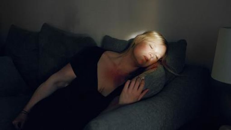 A woman lying on her side, asleep.