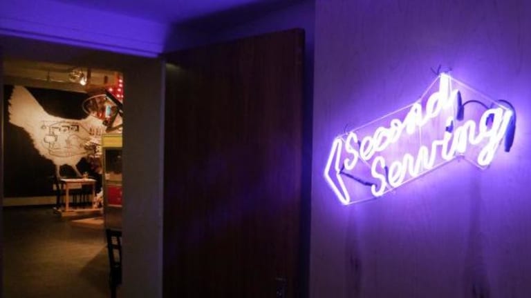 A neon sign directs people towards Second Sewing.