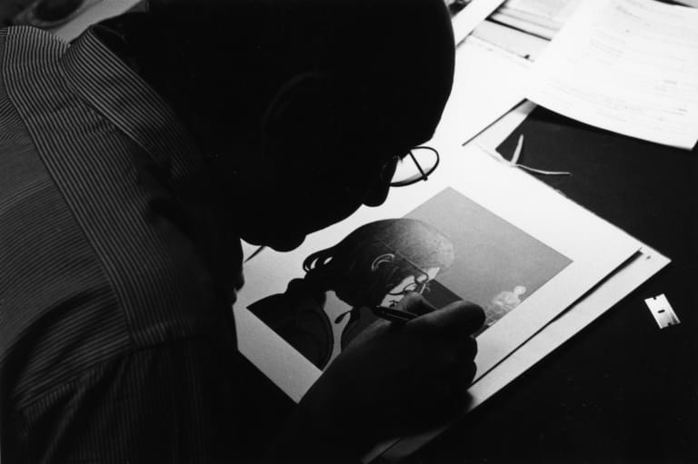 A black and white photograph of Milton Glaser working