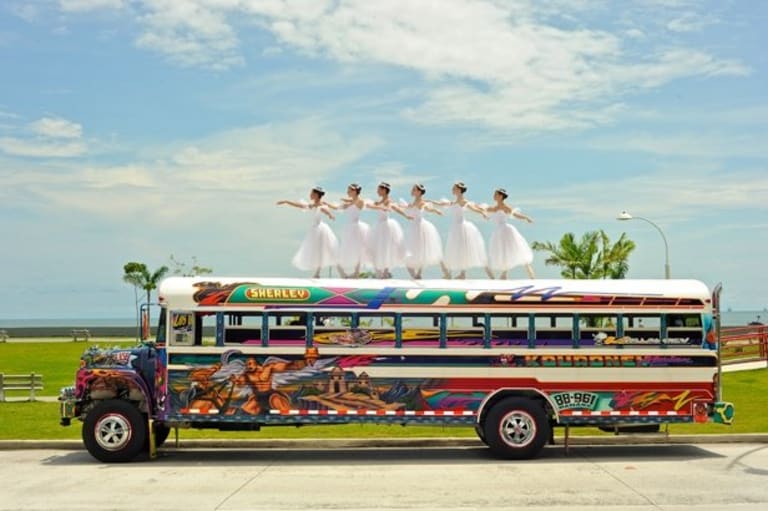 Six girls are dancing on top of the bus