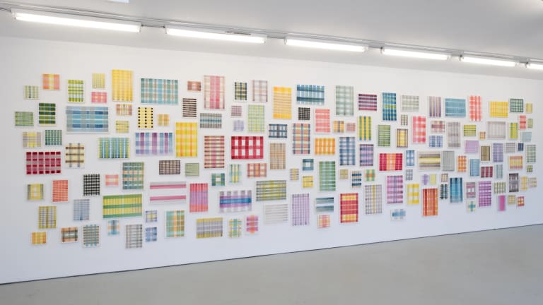 Untitled, 2021, secco fresco by Michelle Grabner. A series of small paintings of different kinds of plaid hung on a white wall of a gallery.