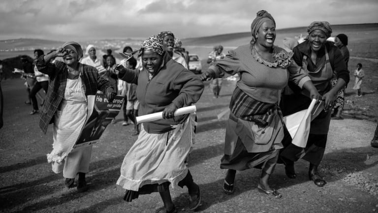 Women in dresses dancing and laughing.