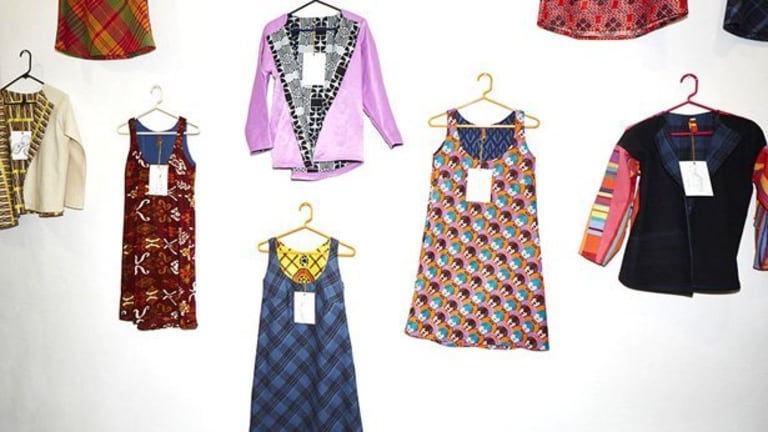 Shirts and jackets on hangers are arranged on a white background. Each article of clothing has a pattern, like blue plaid and checkered.