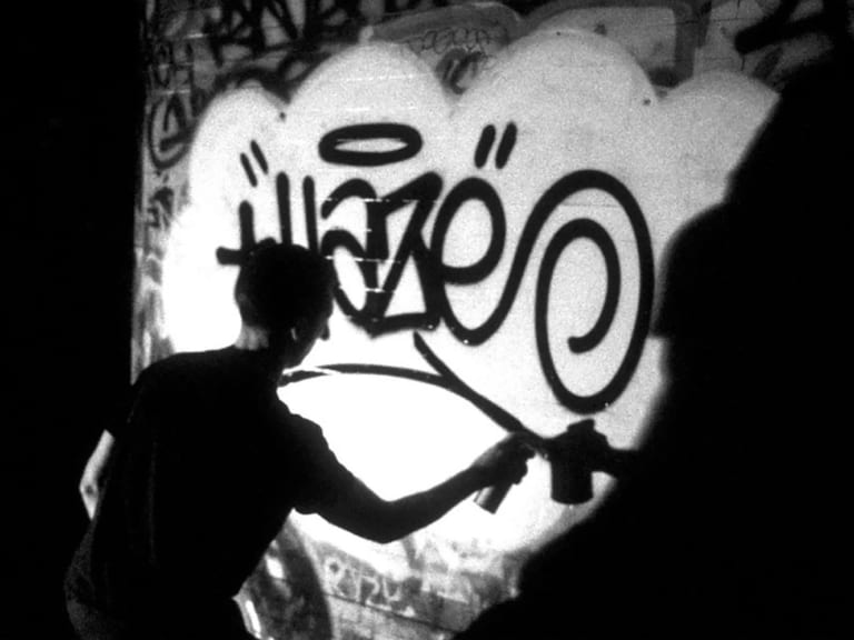 Black and white photo of Eric Haze tagging on the wall