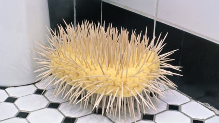 A sponge with spikes on bathroom floor.