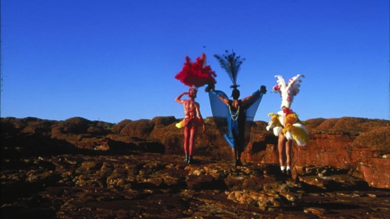 Three costumed people on a rocky landscape