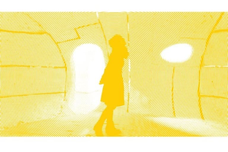 A yellow photo of a woman walking through an art installation