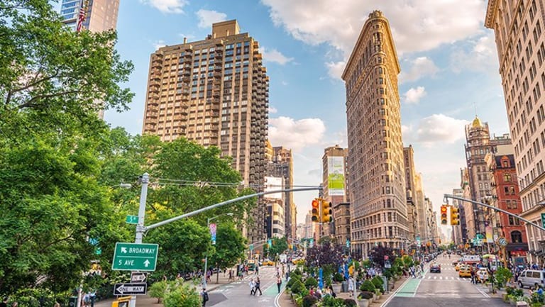A color photograph of the Flatiron Building and surrounding buildings and streets.