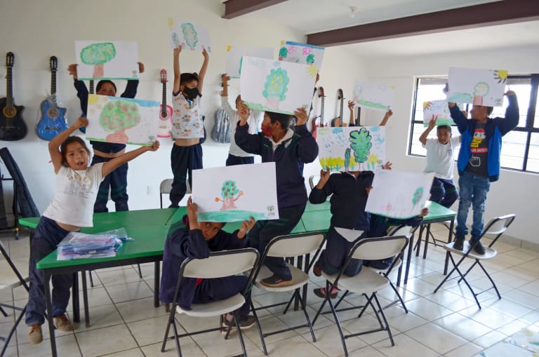 Students show their paintings in watercolor class in Mesa Rica, Estado de México, 2023.