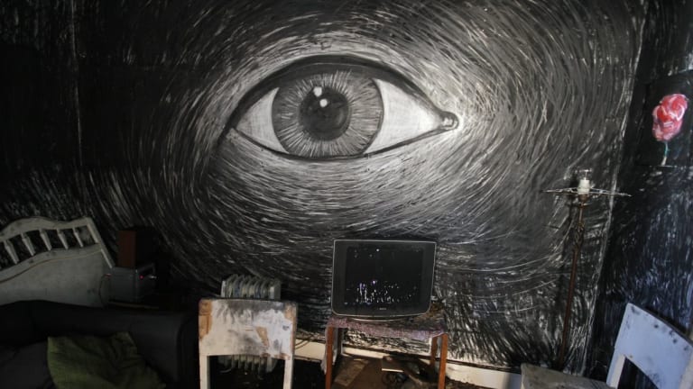 black and white drawing of an eye on a wall