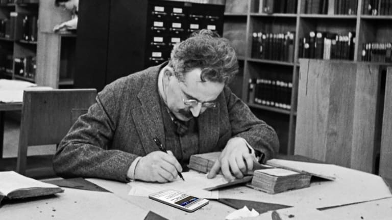 Walter Benjamin working in the library while reading Degree Critical on his smartphone.