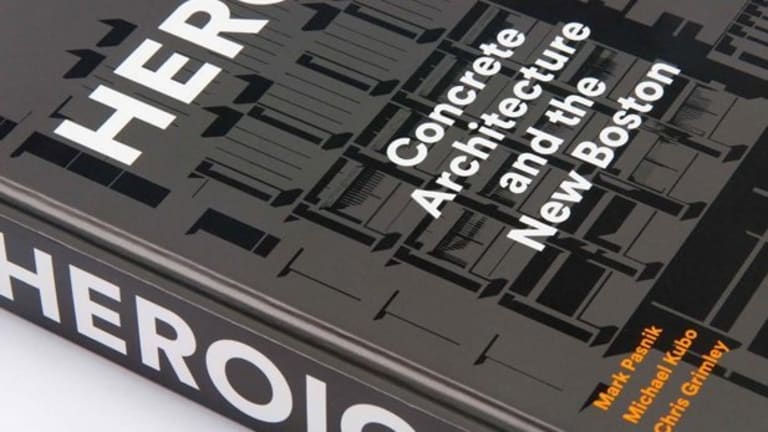 It is a close-up of great books with black floorpan as the front cover design with the title in white block lettering, saying "Concrete Architecture and the New Boston." The spine of the book has white block lettering saying "Heroic" and at the bottom of the front cover in orange lettering lists the authors names.