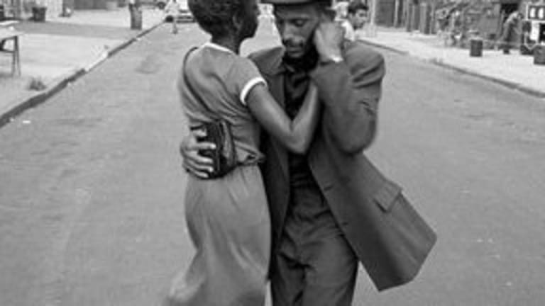 A woman and man dancing together in the street.