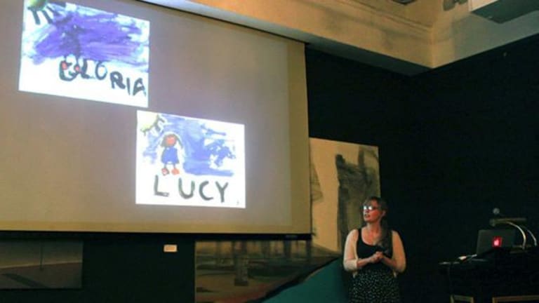 a female giving a presentation on children's artwork